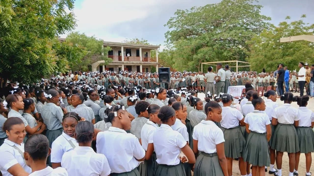 Les élèves du Collège de l'Étoile rassemblés dans la cour, en uniforme blanc et vert.